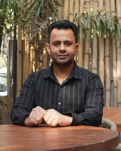 Anshul Wadhwa, co-founder of AptiGuide, seated at a wooden table