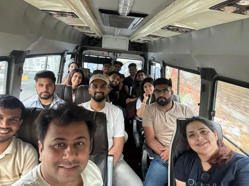 A group smiling on a bus.
