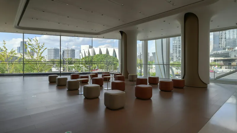 Circular stools arranged beside broad windows in a spacious room