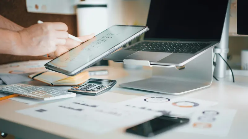 Laptop, calculator and financial documents on a desk