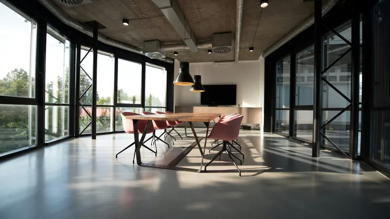 Meeting table and chairs in an empty room with glass walls