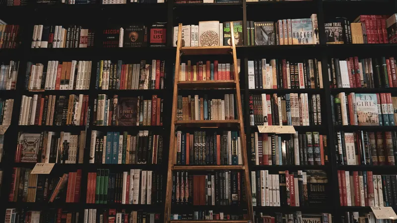 Wooden ladder beside tall library shelves filled with colourful books