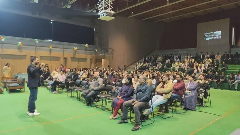 An auditorium audience facing Anshul Wadhwa as he speaks into a microphone