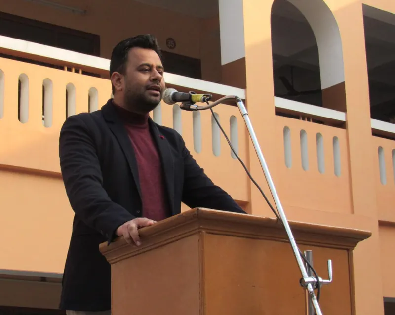 A speaker at a wooden podium, Anshul Wadhwa addressing the gathering