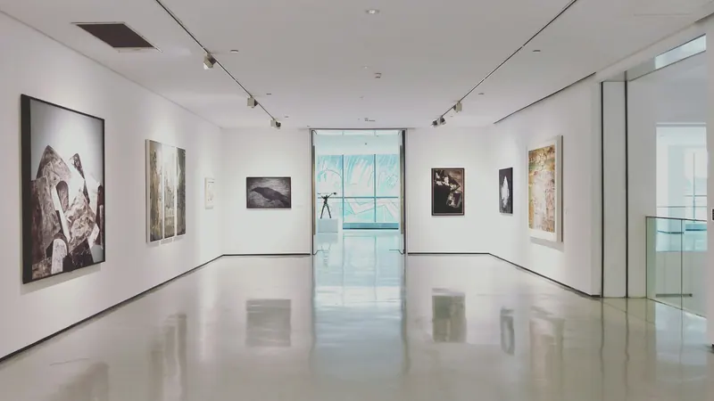 Empty gallery corridor with framed artworks hanging on white walls