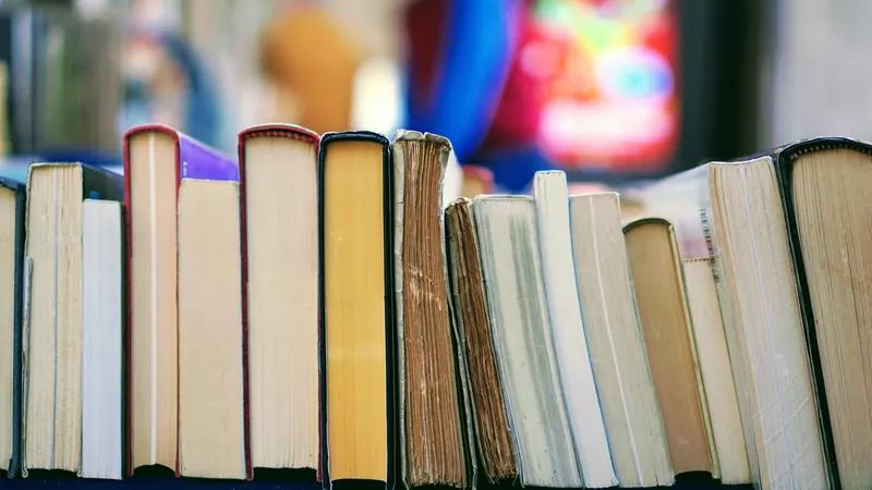 Upright books with colourful covers arranged together on a shelf