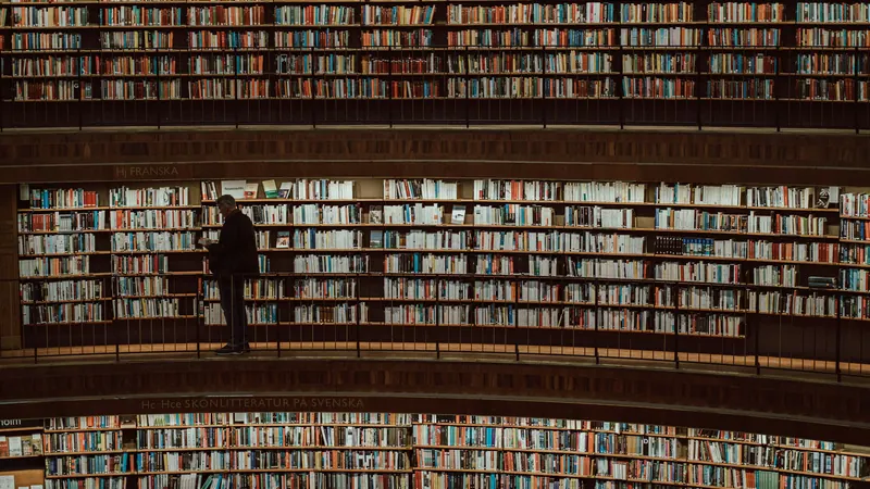 Tall curved library shelves filled with books across several levels