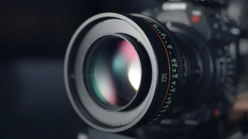 Close view of a camera lens with softly reflected coloured light