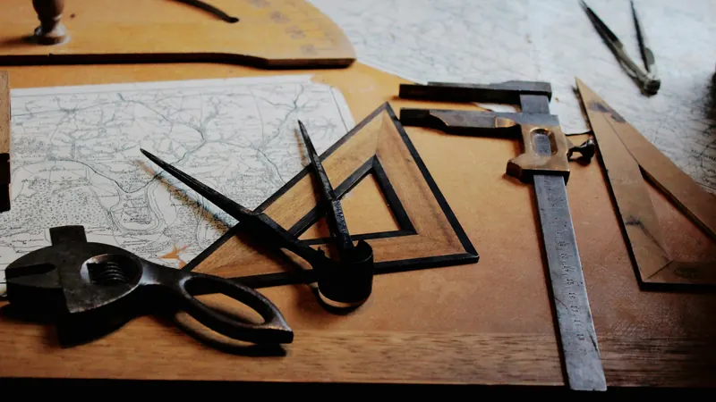 Rulers and drafting tools arranged across paper drawings on a desk