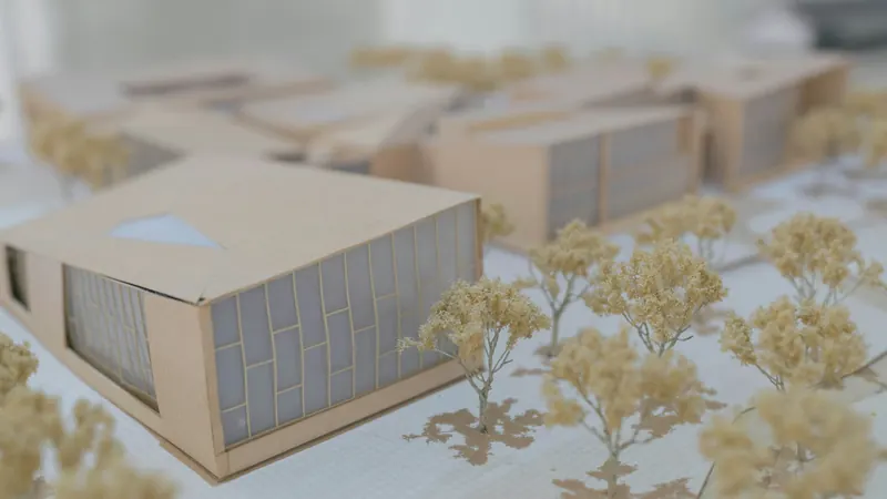 Small architectural model with rectangular buildings and miniature trees on display
