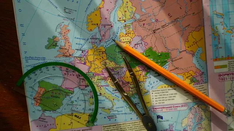 Yellow pencil lying diagonally across a colourful map of Europe