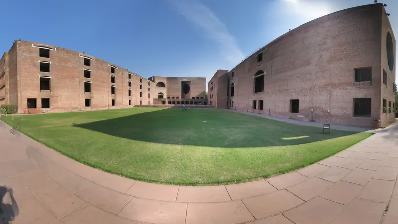 Brick buildings surrounding a broad green courtyard at IIM Ahmedabad