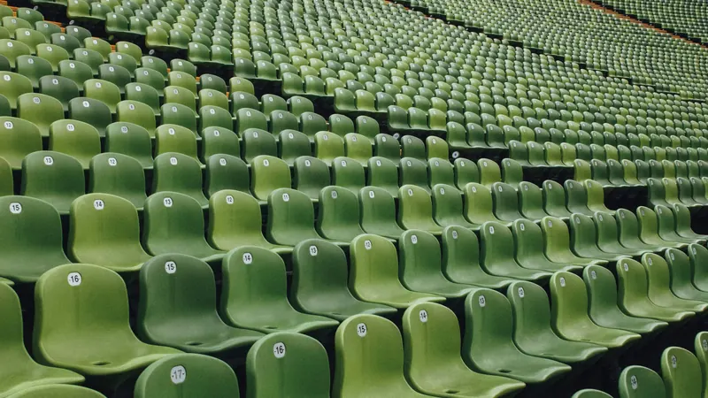 Rows of green stadium seats arranged across a large stand
