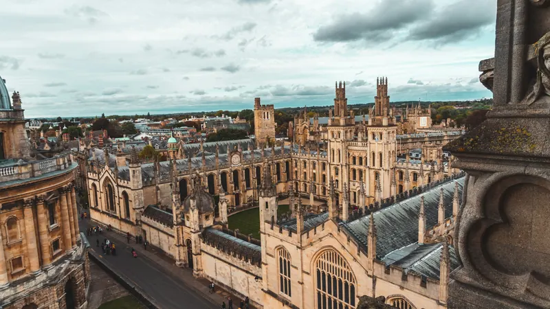 Oxford stone buildings and towers beneath a partly cloudy sky