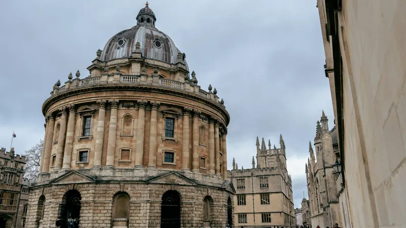 Round stone library building beside a cobbled street in Oxford