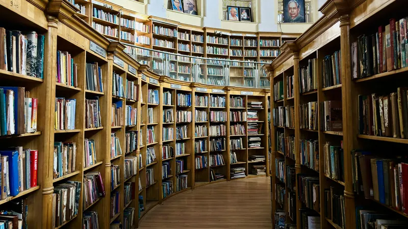Long library aisle lined with tall wooden shelves of books